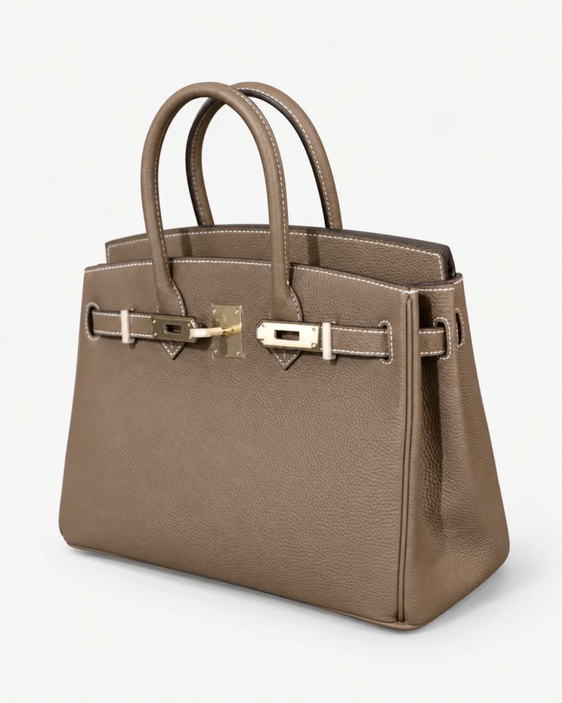 Taupe double-handle leather bag on a pale studio background