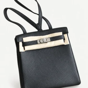 Black grained leather backpack on a pale studio background
