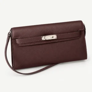 Saddle Red elongated leather shoulder bag on a pale studio background