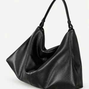 Black split-leather shoulder bag on a pale studio background