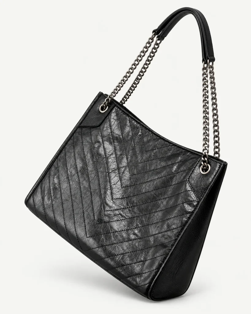 Black split-leather chain-handle hobo on a pale studio background