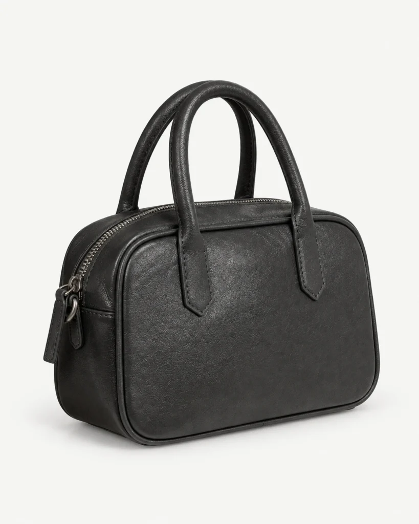 Black leather bowling bag on a pale studio background