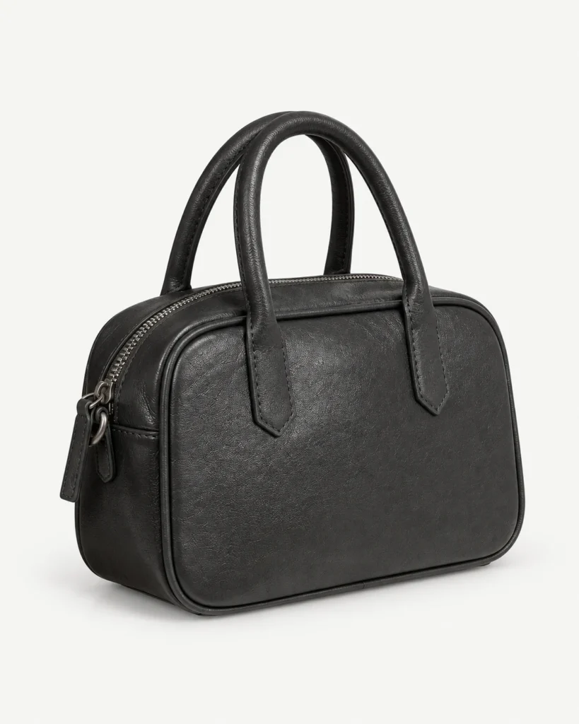 Black leather bowling bag on a pale studio background