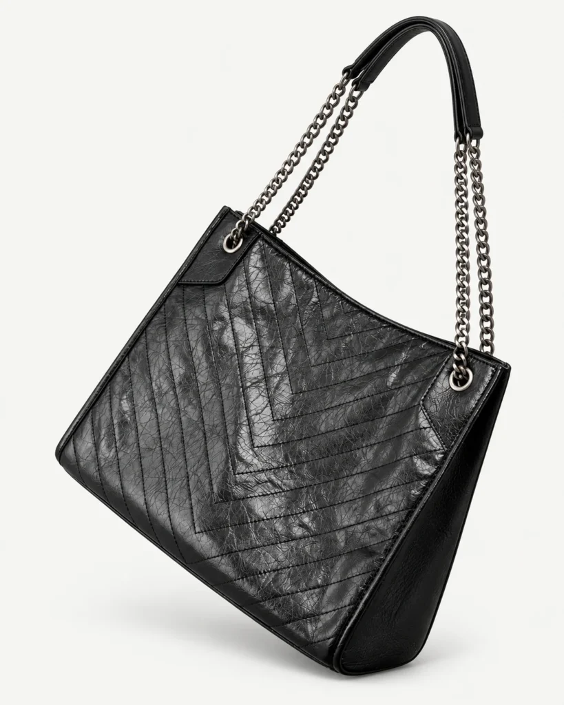 Black split-leather chain-handle hobo on a pale studio background
